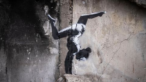 Ein Motiv von Banksy zeigt ein Mädchen, das einen Handstand macht