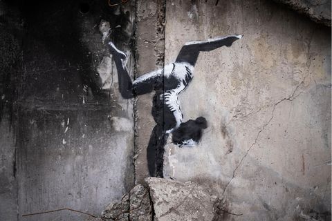 Ein Motiv von Banksy zeigt ein Mädchen, das einen Handstand macht