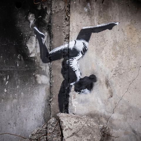 Ein Motiv von Banksy zeigt ein Mädchen, das einen Handstand macht