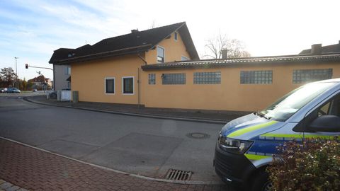 Ein Polizeiauto steht gegenüber einem Haus. In Weilheim hat sich eine Bluttat mit vier Toten ereignet