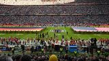 Auf dem Rasen der zum Football-Stadion umgebauten Allianz-Arena halten Uniformierte eine riesige US-Flagge