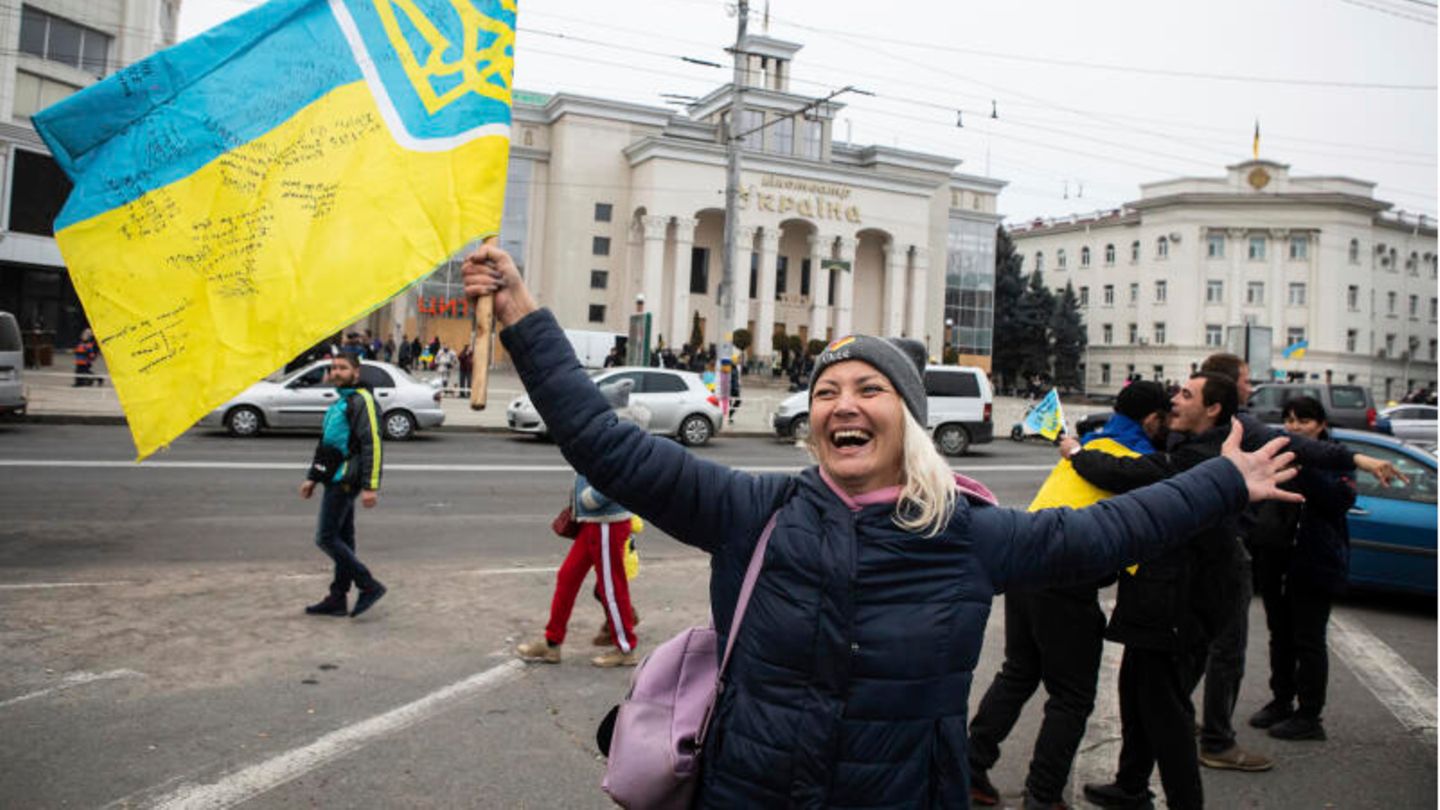 Eine Frau schwenkt in der Innenstadt von Cherson eine ukrainische Flagge Eine Frau schwenkt in der Innenstadt von Cherson eine ukrainische Flagge