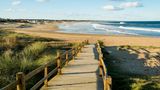 Ein Steg führt durch die Dünen zum Strand in Uruguay.