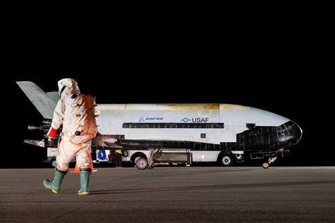 Ein Astronaut läuft auf die gelandete Boeing X-37B zu