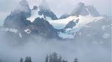 Dieses Foto zeigt Schneebedeckte Gipfel, die von Nebel umgeben sind