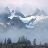 Dieses Foto zeigt Schneebedeckte Gipfel, die von Nebel umgeben sind