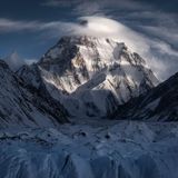 Die Sonne leuchtet auf diesem Foto den Gipfel eines Berges aus, während der Rest im Schatten bleibt