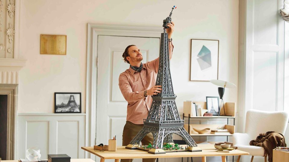 Lego Eiffelturm: Junger Mann setzt die Spitze auf den 1,50 Meter hohen Lego Eiffelturm