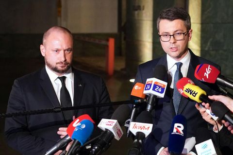 Polens Regierungssprecher Piotr Müller (r.) und Sicherheitsberater Jacek Siewiera treten für ein erstes Statement vor die Presse