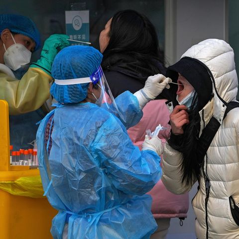 China: Eine Frau testet eine andere Frau auf Corona, indem sie einen Rachenabstrich nimmt