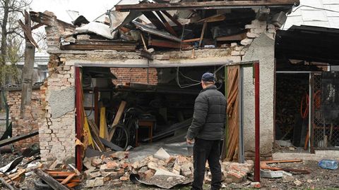 Ein Mann betrachtet sein beschädigtes Haus nach einem Raketenangriff