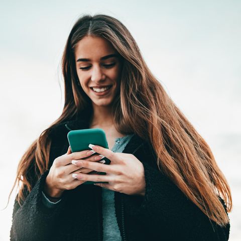 Frau mit Handy freut sich