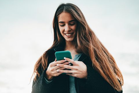 Frau mit Handy freut sich