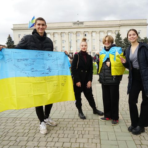 Junge Ukrainer mit blau-gelber Flagge auf dem Freiheitsplatz