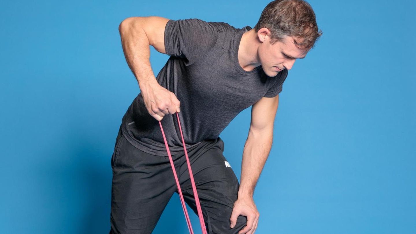 Physiotherapeut zeigt Übung gegen Rückenschmerzen