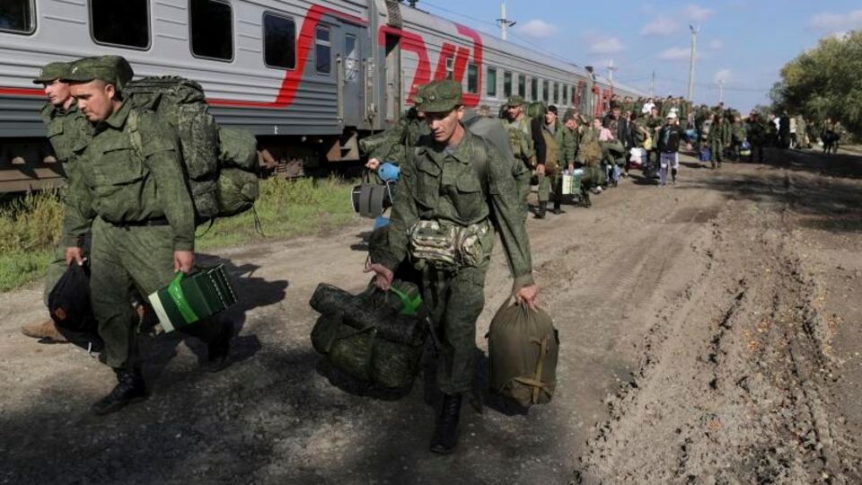 Russische Rekruten gehen auf einem Bahnhof in Prudboi.