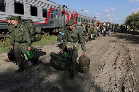 Russische Rekruten gehen auf einem Bahnhof in Prudboi.