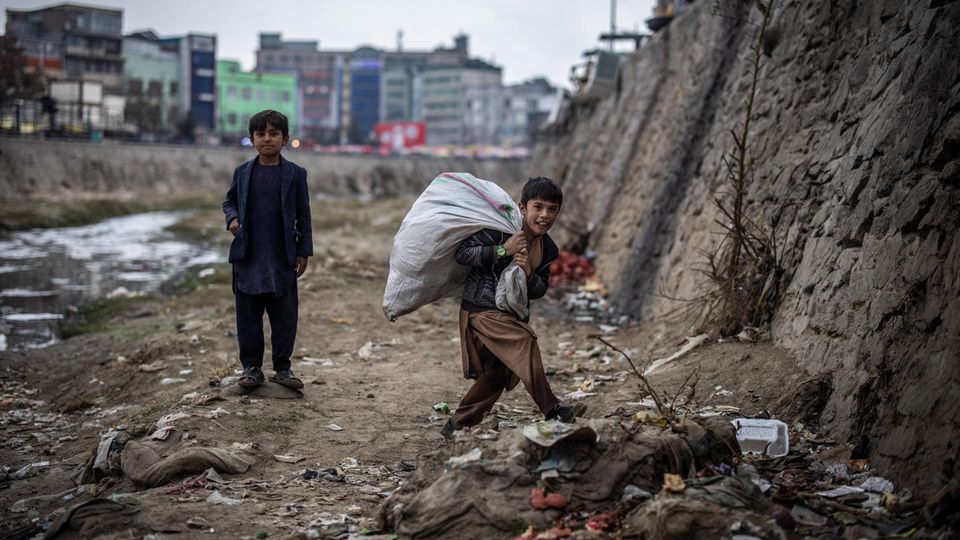 Zwei Jungen suchen am Ufer des Kabul-Flusses nach Plastikflaschen