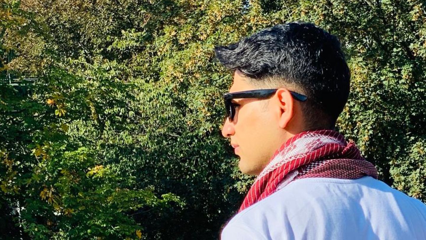 Afghanistan Hamburg Kabul Ein junger Mann mit Sonnenbrille steht an einer Brücke