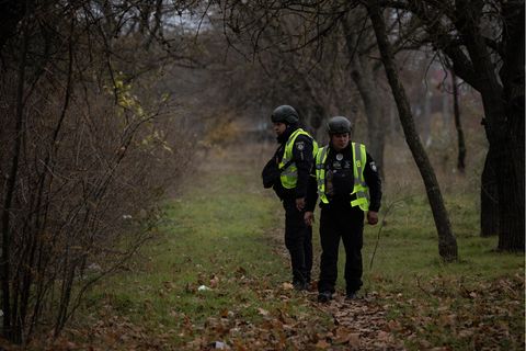 Ermittler der Polizei durchsuchen und erfassen in einem Stadtpark in Cherson, Ukraine, Beweise