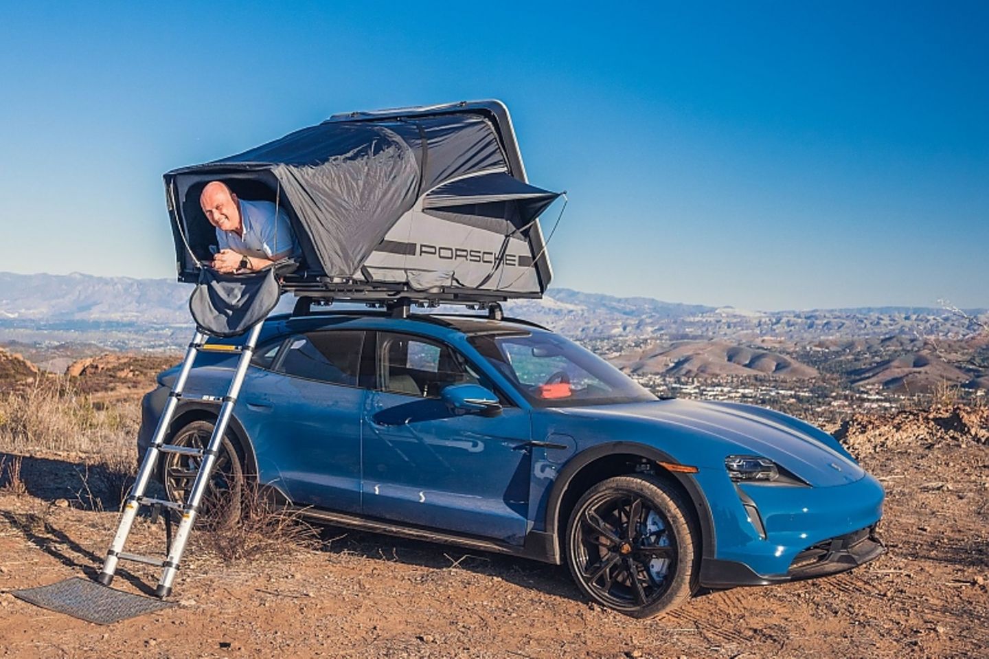Porsche Taycan mit Dachzelt und ungebetenem Passagier