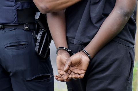 Ein US-Polizist führt eine Schwarzen mit Handschellen hinter dem Rücken ab