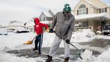 Zwei Männer räumen Schnee mit Schaufeln zur Seite