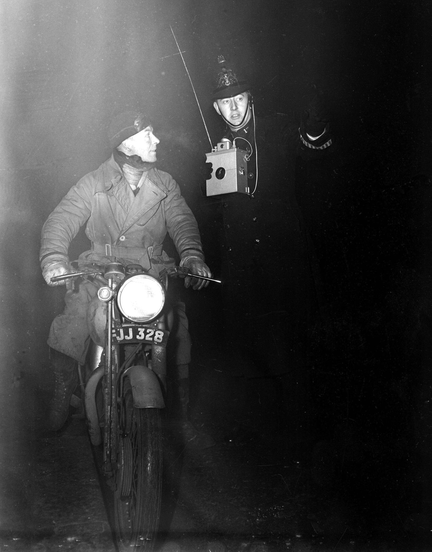 Ein Polizist hilft im dichten Smog von London einem Motorradfahrer