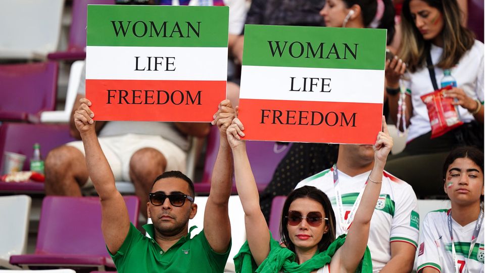 Doha, Katar: Beim WM-Vorrundenspiel England gegen den Iran zeigen sich iranische Fans im Khalifa International Stadion solidarisch mit den Protesten in ihrem Heimatland. Exemplarisch steht die Aufschrift "Woman Life Freedom" auf den Plakaten.