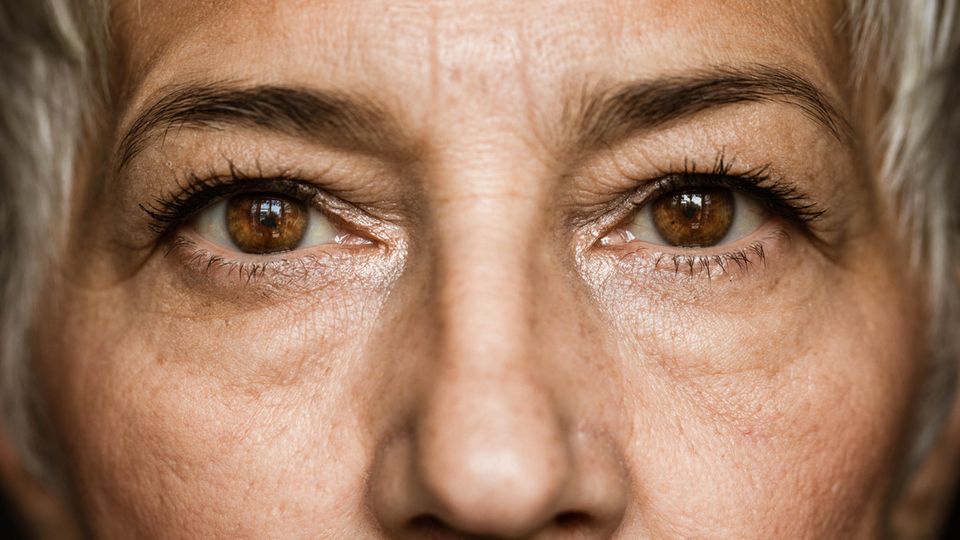 Eine Frau mit braunen Augen guckt intensiv in die Kamera