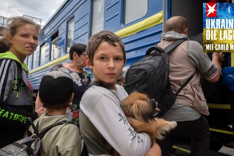 Ein Junge hält seinen Hund im Arm, als er mit Familienmitgliedern einen Zug besteigt
