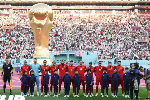 Spieler des Iran stehen bei der Nationalhymne vor dem übergroßen WM-Pokal
