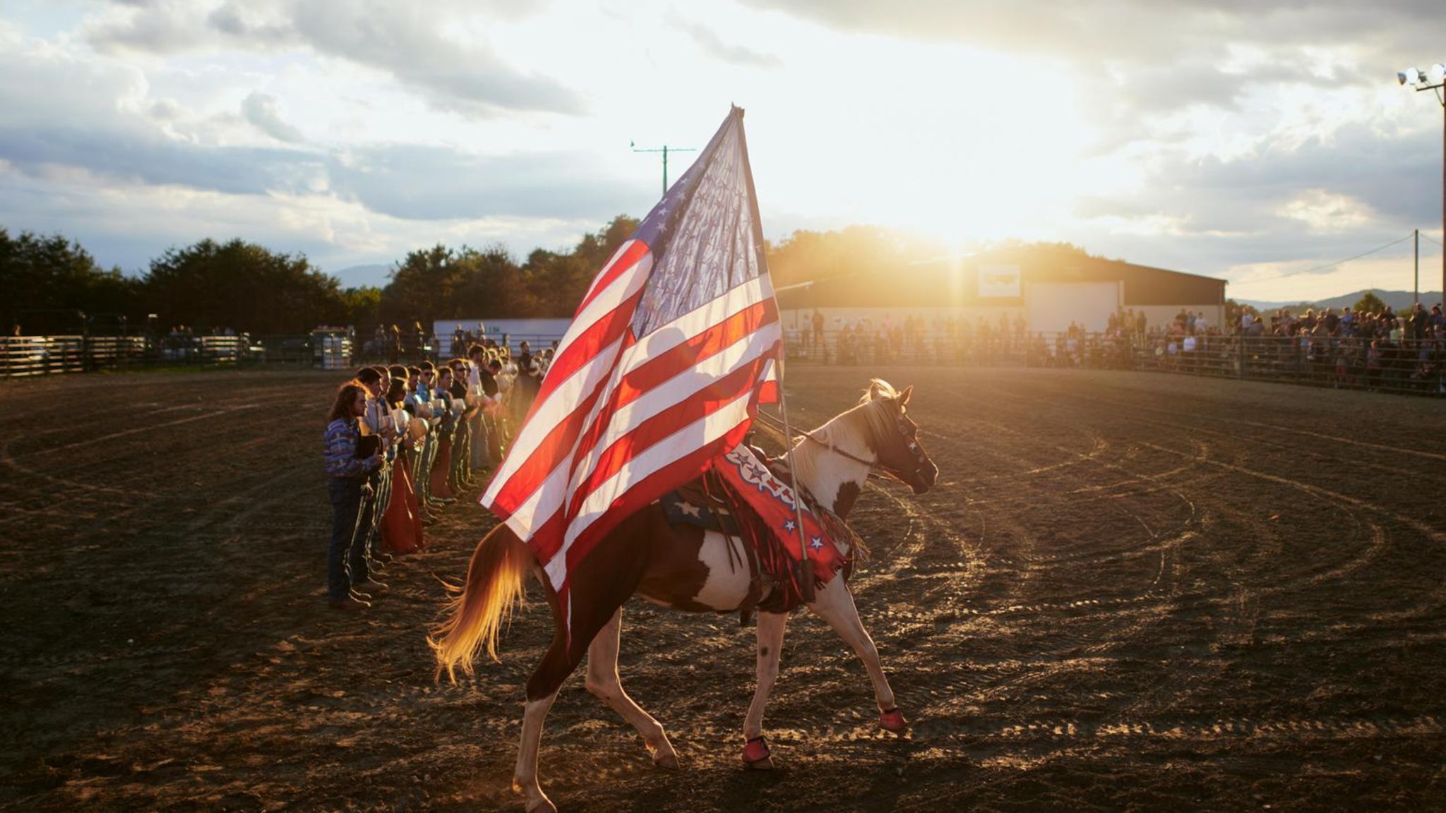 Eine Reiterin präsentiert die Flagge auf dem Rodeofeld