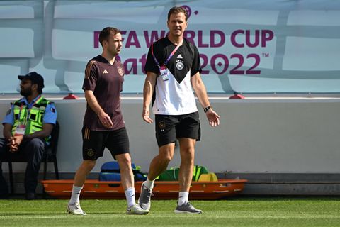 Während die DFB-Spieler wie Mario Götze (l.) sich versuchen, auf das nächste Spiel vorzubereiten, darf Manager Oliver Bierhoff viele Fragen zur "One Love"-Binde beantworten