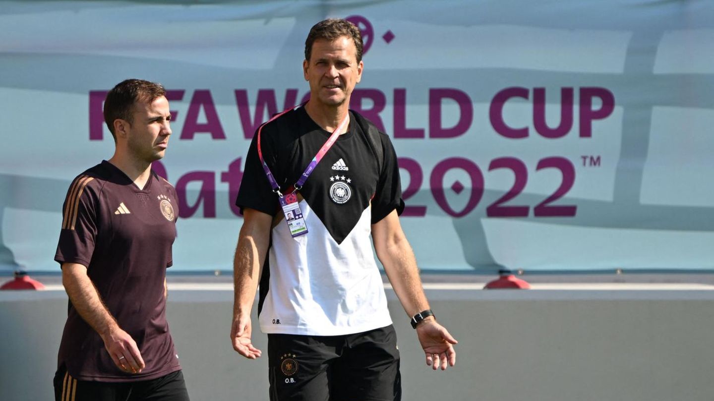 Während die DFB-Spieler wie Mario Götze (l.) sich versuchen, auf das nächste Spiel vorzubereiten, darf Manager Oliver Bierhoff viele Fragen zur "One Love"-Binde beantworten