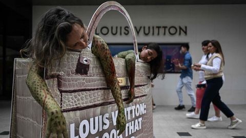 Kuala Lumpur, Malaysia. Tierschutzaktivisten haben sich als Python verkleidet in einer Louis Vuitton-Tasche vor dem gleichnamigen Geschäft positioniert, um gegen die Verwendung von Schlangen für die teuren Handtaschen zu protestieren.