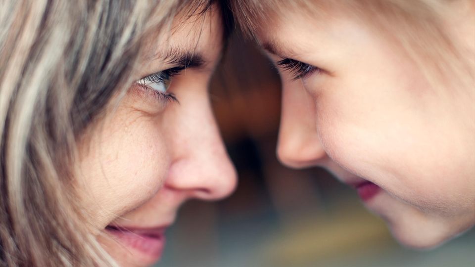 Eine Frau und ein Mädchen gucken sich intensiv in die Augen.