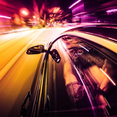 Ein Auto rast durch die Stadt bei Nacht