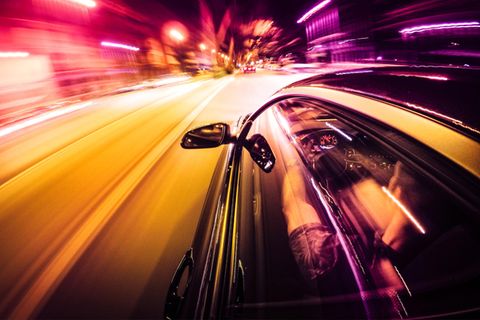 Ein Auto rast durch die Stadt bei Nacht