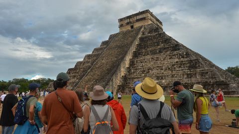 Touristen stehen vor der Maya-Pyramide in Chichen Itza