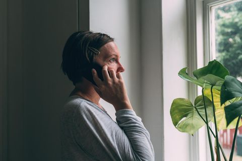 Eine Frau hält sorgenvoll den Telefonhörer in der Hand