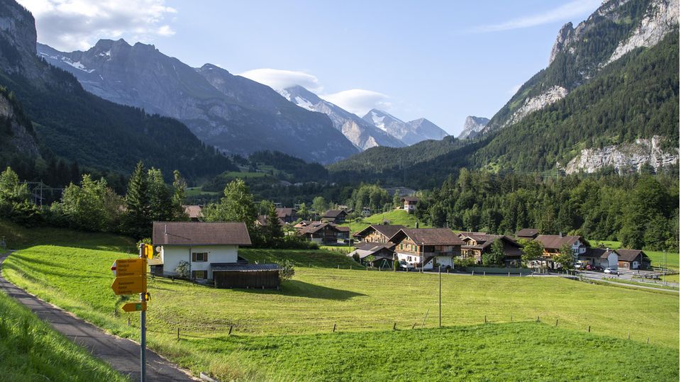 Grüne Wiesen und ein paar Häuser umgeben von Bergen: die Gemeinde Mitholz in der Schweiz