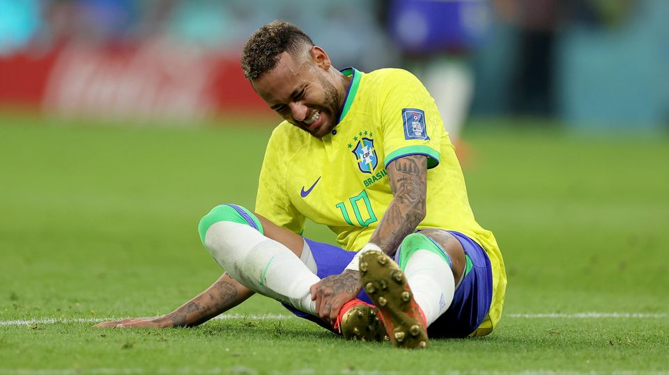 Mit schmerzverzerrtem Gesicht sitzt Neymar im WM-Spiel gegen Serbien auf dem Platz.