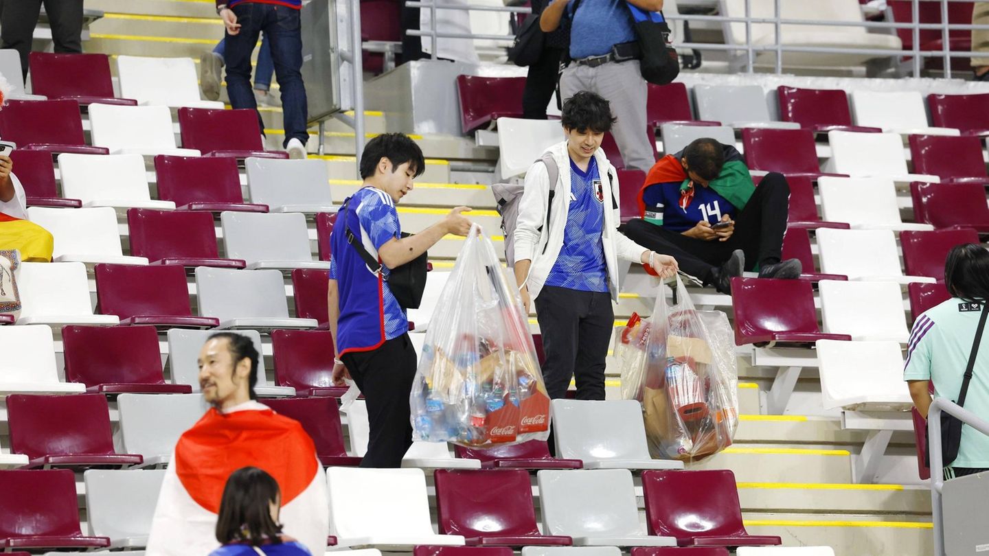 Japanische Fans räumen nach dem Spiel gegen Deutschland im Khalifa International Stadium auf