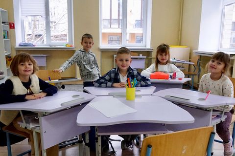 Kinder an Schultischen, Ukraine