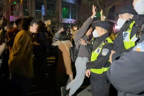 Chinesische Demonstranten stehen Polizisten gegenüber.