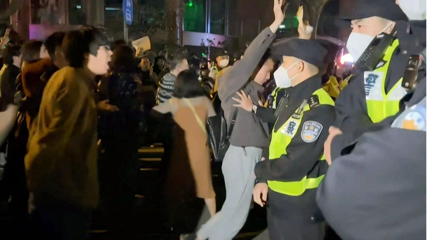 Chinesische Demonstranten stehen Polizisten gegenüber.