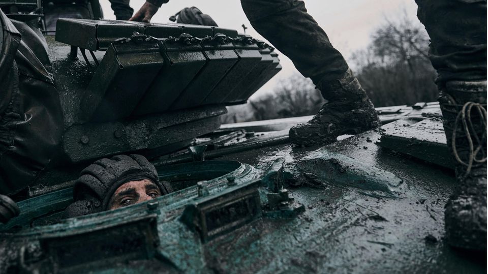 Ein ukrainischer Soldat späht aus einem erbeuteten russischen Panzer an der Frontlinie in der Region Donezk