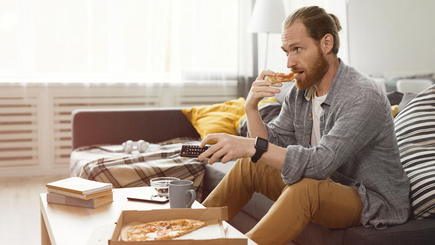 Mann isst Pizza auf der Couch Mann isst Pizza auf der Couch