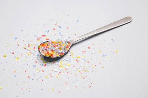 Bunte Mikroplastikpartikel auf einem Löffel